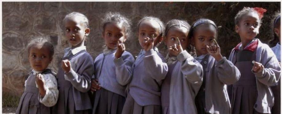 Schülerinnen zeigen nach ihrer Polio-Schutzimpfung ihre farbmarkierten Finger
