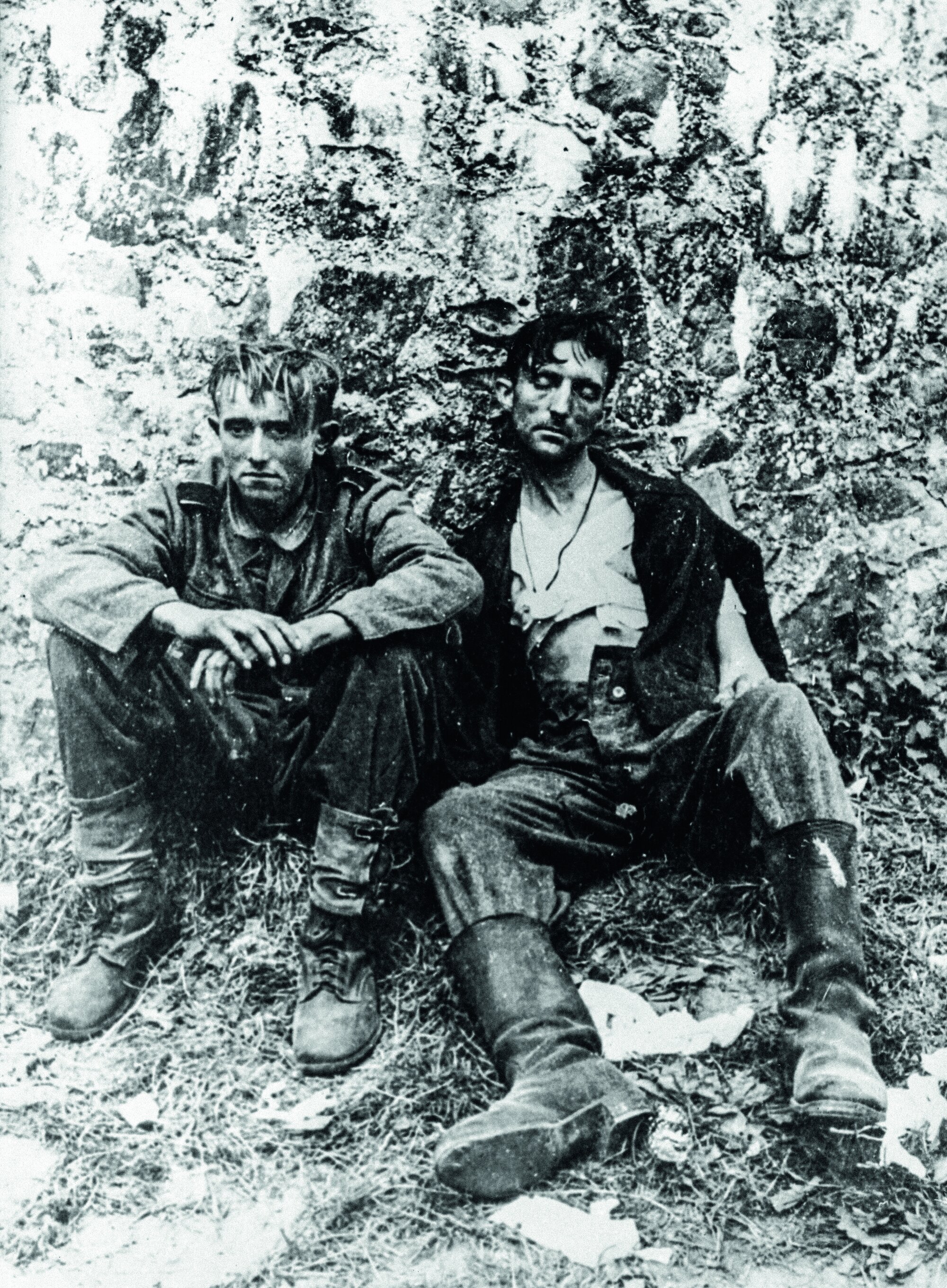 Zwei erschöpfte deutsche Soldaten nach dem Niederlegen der Waffen bei Kriegsende, Anfang Mai 1945