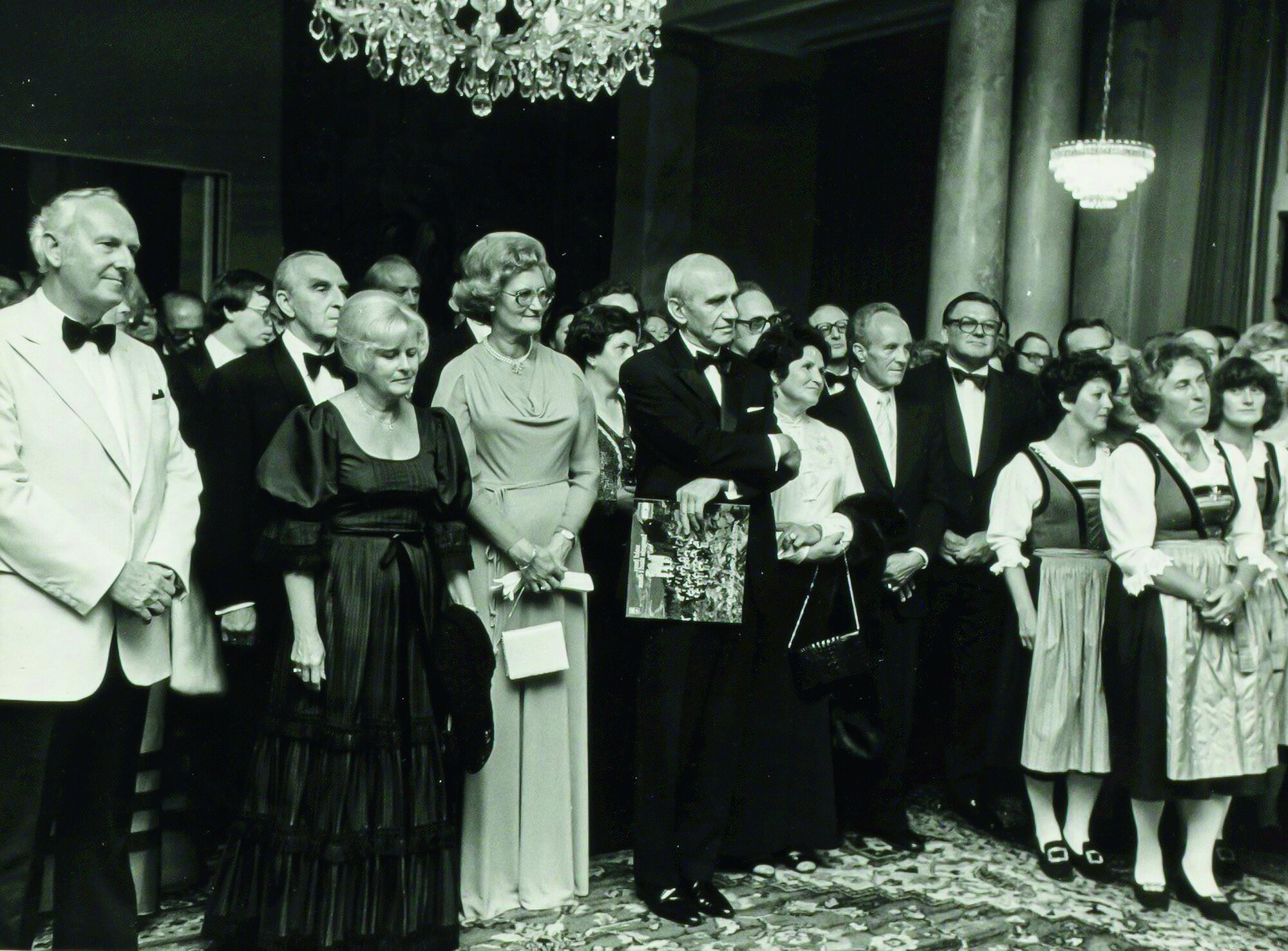 Eröffnung 1977: Das Foto zeigt die Eröffnungszeremonie des Carinthischen Sommers 1977 im Bambergsaal des Parkhotels Villach, wo 1932 der RC Villach gegründet wurde. Man erkennt links im weißen Sakko den Gründungsintendaten Helmut Wobisch (RC Wien-West und Ehrenmitglied RC Villach), rechts dahinter in der 2. Reihe Wolfgang Wick (RC Klagenfurt und beinahe RI-Präsident), in der Mitte (mit Schallplattencover) Bundespräsident Rudolf Kirchschläger, rechts in der ersten Reihe Kärntnerlied-Komponistin und Chorleiterin Gretl Komposch