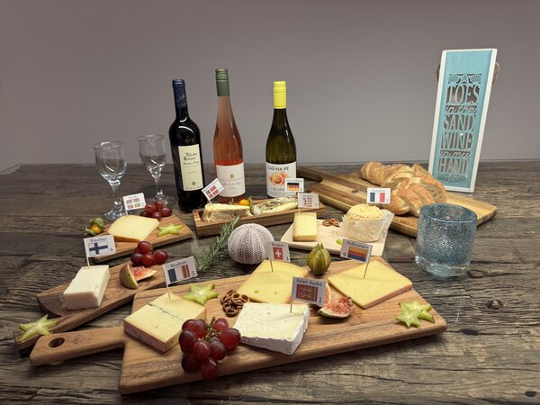 D1940_CharityCheeseTasting_5222990-betty-nina-sigine-img_0897.jpeg Leckere Käsesorten und Wein auf einem Holzbrett