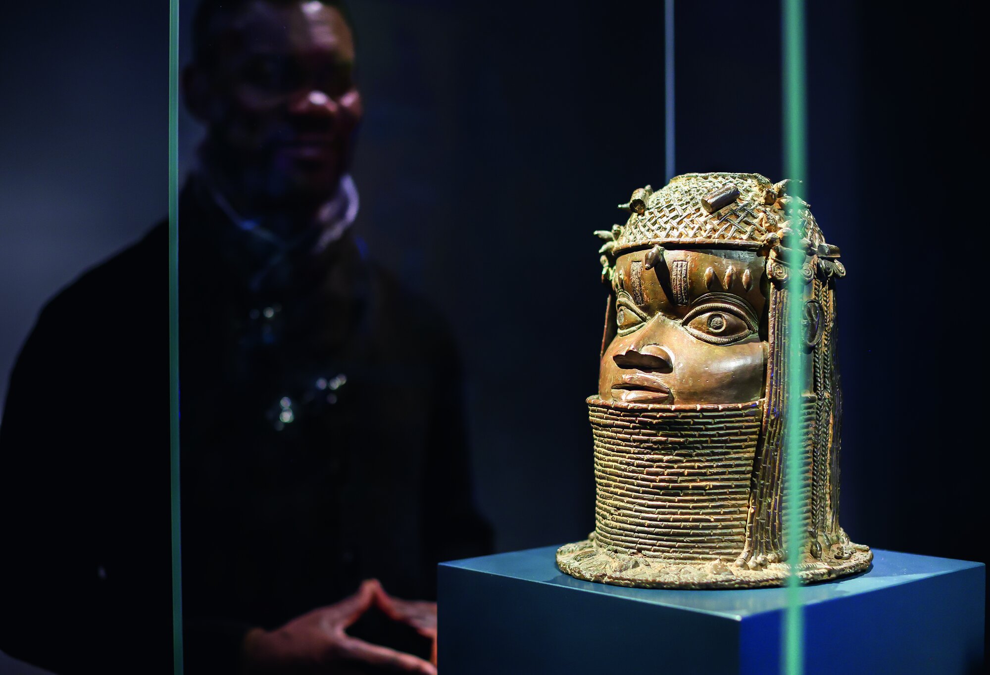 Der nigerianische Künstler Enotie Paul Ogbebor steht an einer Benin-Bronze im Grassi Museum für Völkerkunde zu Leipzig. Das Museum erfindet sich neu und zeigt erstmals nach einer Unterbrechung wieder Benin-Bronzen