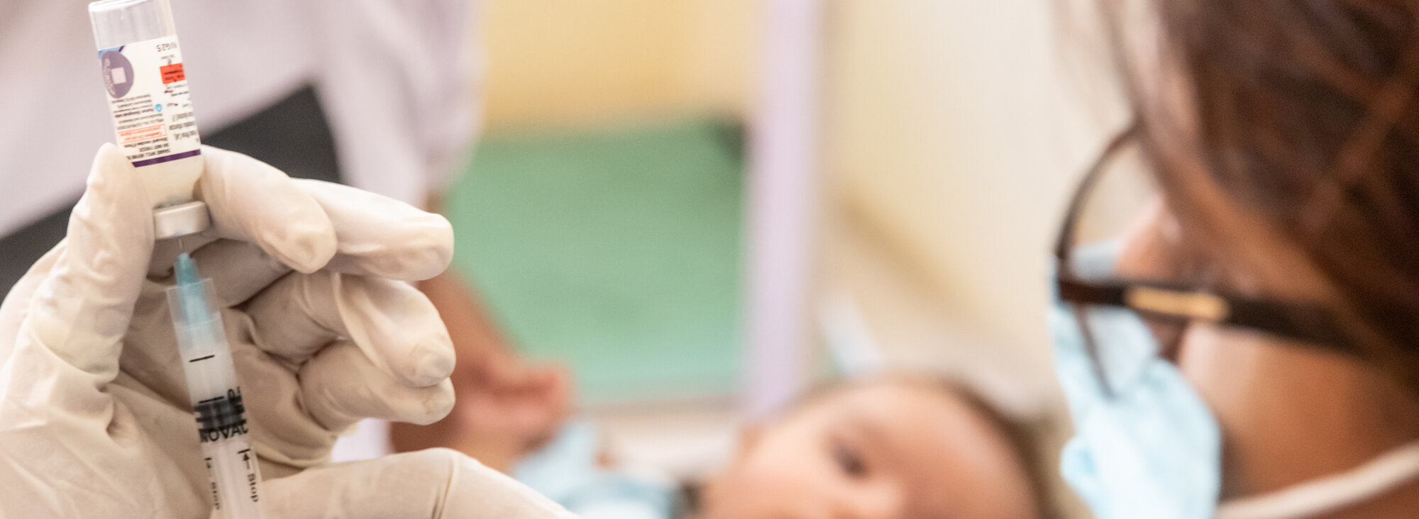 Ein Impfhelfer in Indien zieht Serum auf eine Spritze, um ein Baby gegen Polio zu impfen