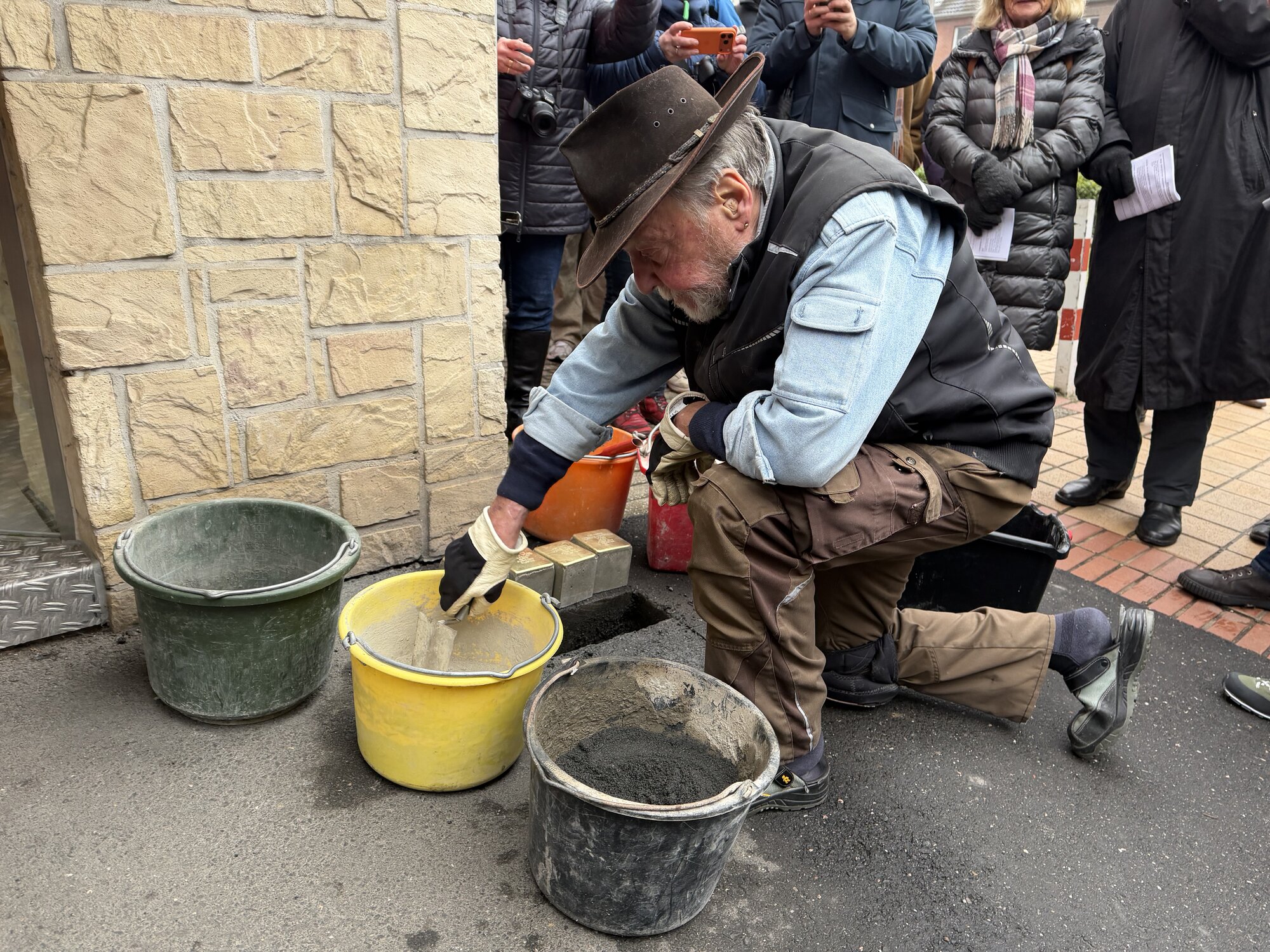 Der Künstler Gunter Demnig bei der Verlegung der Stolpersteine (siehe Mitte)