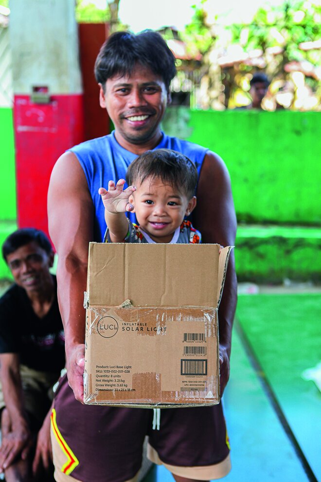 Haben sichtlich Spaß: Ein junger Mann mit dem Nachbarskind bei der Hilfsgüter-Verteilung in San Vicente