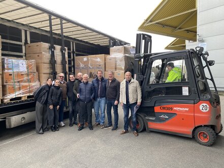 Eine Gruppe steht vor einem LKW mit Hilfgütern.