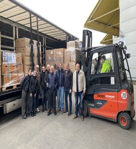 Eine Gruppe steht vor einem LKW mit Hilfgütern.