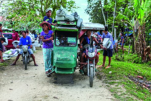 Die Hilfsgüter müssen nach Hause: Mitunter liegen noch eine Stunde Fahrt vor den Menschen, die zu dritt mit Wasserfilter, ShelterKit und Co. auf einem Motorroller oder in einem voll beladenen Bao Bao sitzen, so werden auf den Philippinen Tuktuks bezeichnet