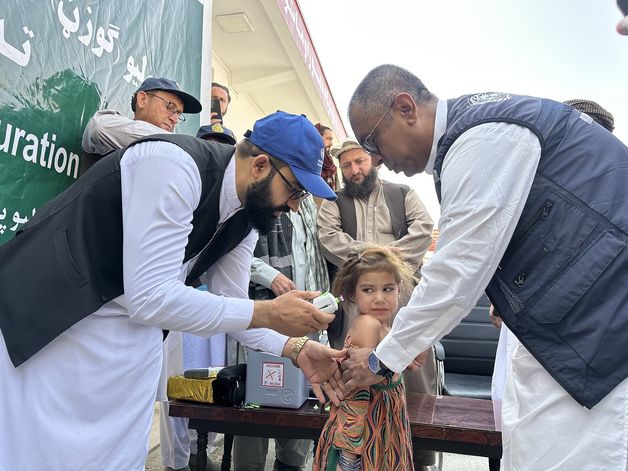 Das afghanische Kind blickt ängstlich in Richtung Impfgerät. Das afghanische Kind blickt ängstlich in Richtung Impfgerät.