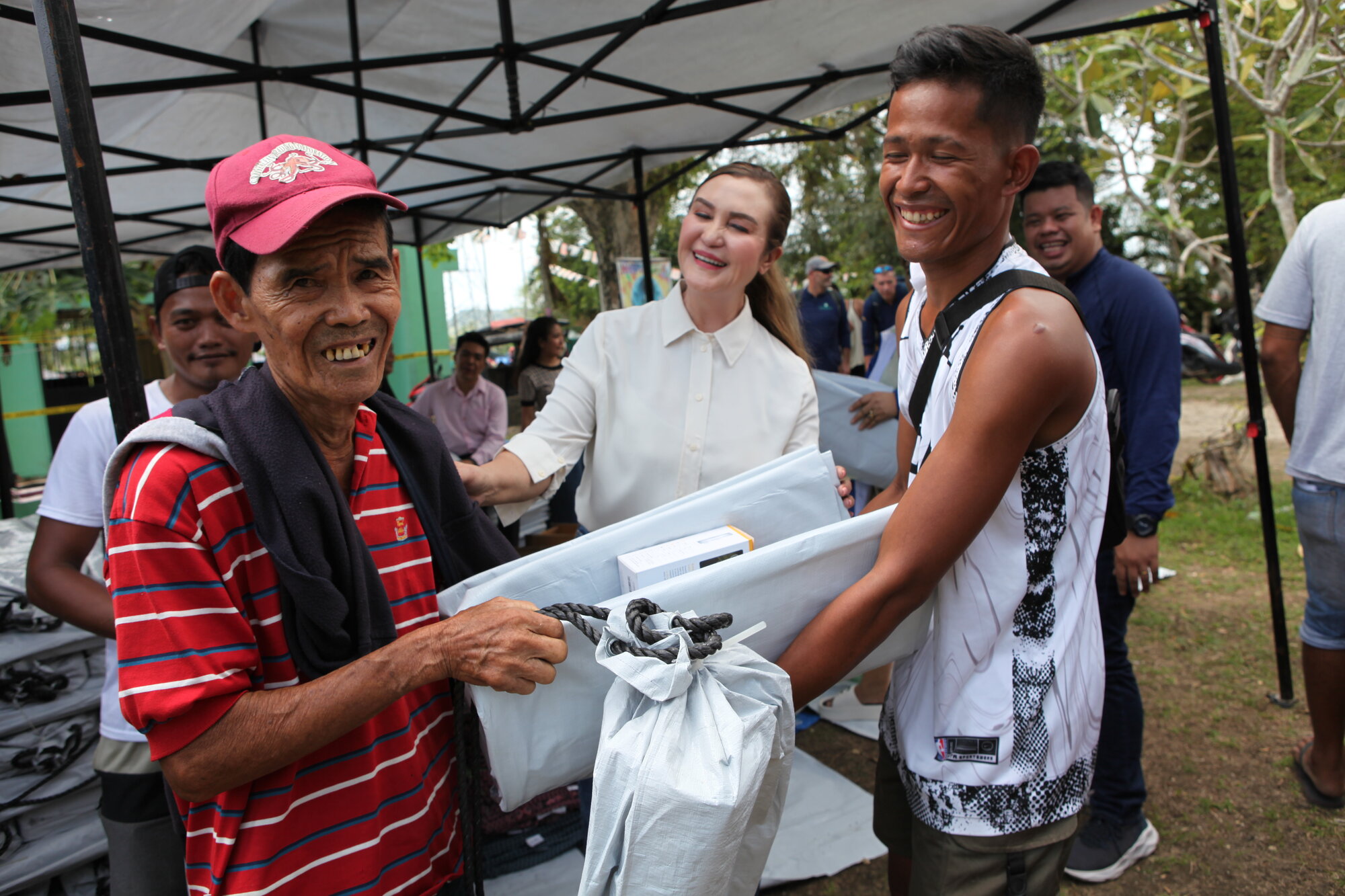 Trotz der Vielzahl an Naturkatastrophen, die die Philippinen schon heimgesucht haben, die Bewohner haben das Lachen noch nicht verlernt. Sich auch ein hilfsbedürftiger Mann, der von Mildred Vitangcol und einem freiwilligen Helfer seine Hilfsgüter erhält.