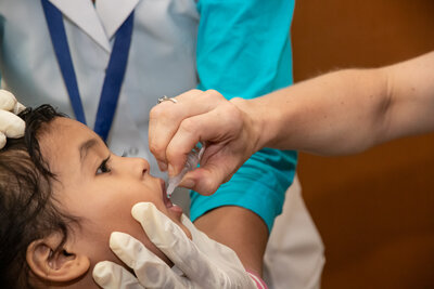 Ein Kind in Indien wird mit zwei Tropfen Schluckimpfung gegen Polio geschützt
