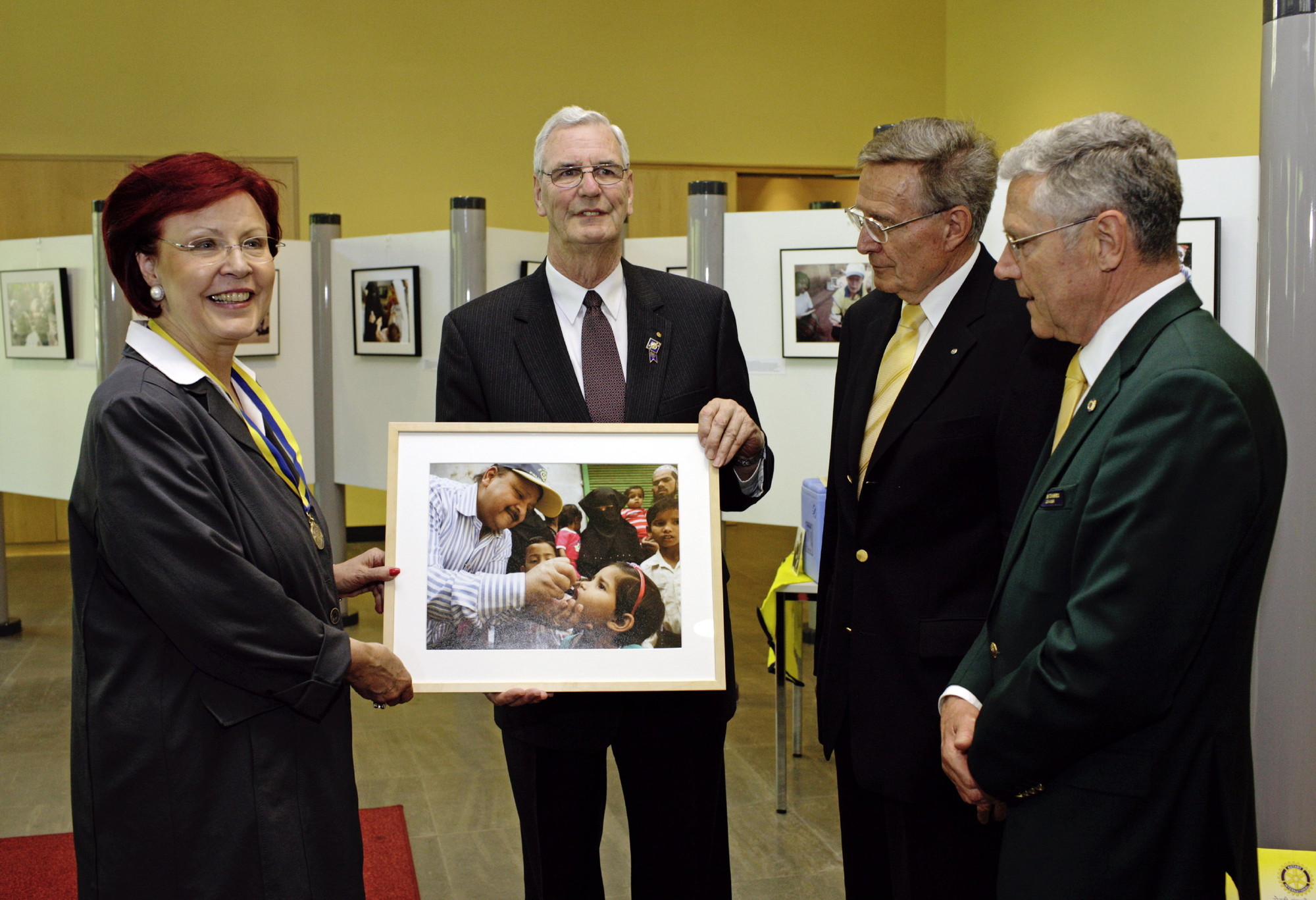 Jean-Marc-Giboux-Ausstellung, polio, Bild 23, Die damalige Bundesministerin für wirtschaftliche Zusammenarbeit und Entwicklung Heidemarie Wieczorek-Zeul und Dr. Robert Scott, Vorsitzender der Rotary Foundation sowie PDG Hans Pfarr (PolioPlus National Advocacy Advisor Germany) und Karl Zieger (Governor Distrikt 1940) bei erster Ausstellungseröffnung