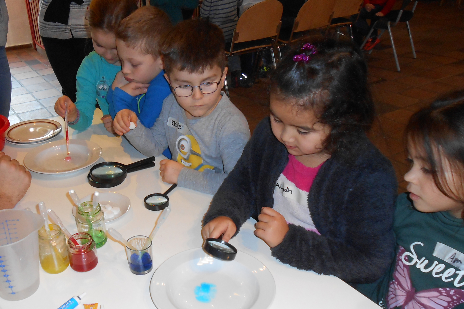 Mit Hilfe von Lupen beobachteten die Kinder an der Station „Zuckerbilder“ die Effekte, die durch mit Farben und Wasser beträufelte Zuckerwürfel entstehen.